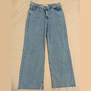 Straight leg light wash jeans with trendy asymmetrical button